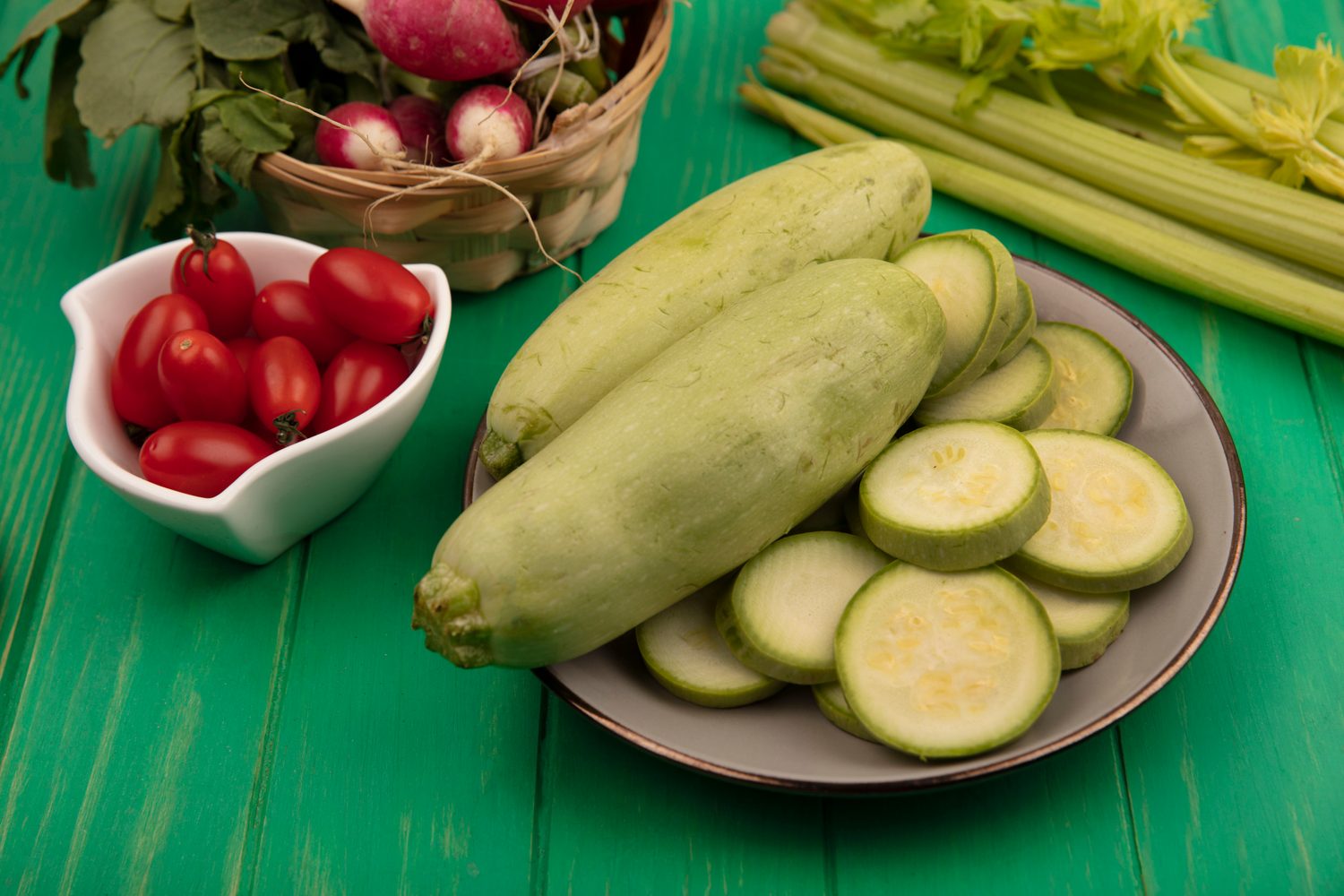 Courgettes vertes et jujubes frais présentés côte à côte sur un étal de marché.